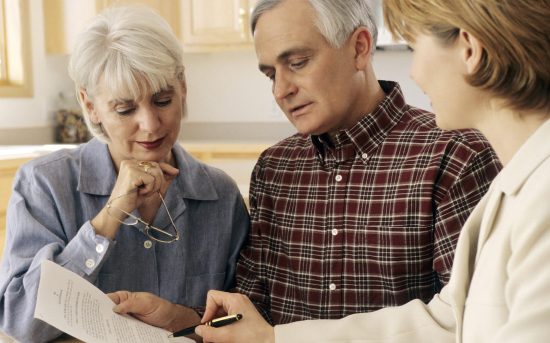 Mature couple talking to financial planner at home