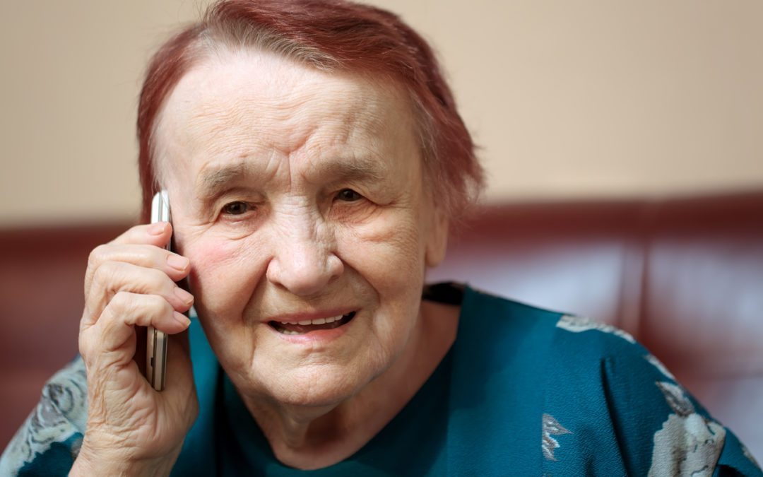 Elderly lady talking on a mobile phone frowning in concentration as she listens to the conversation, close up of her face