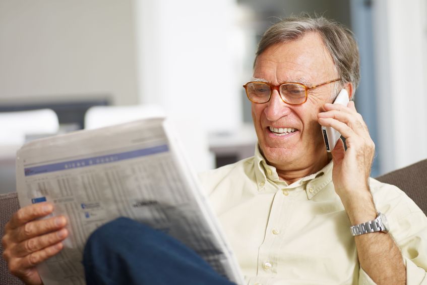 aging investor reading newspaper