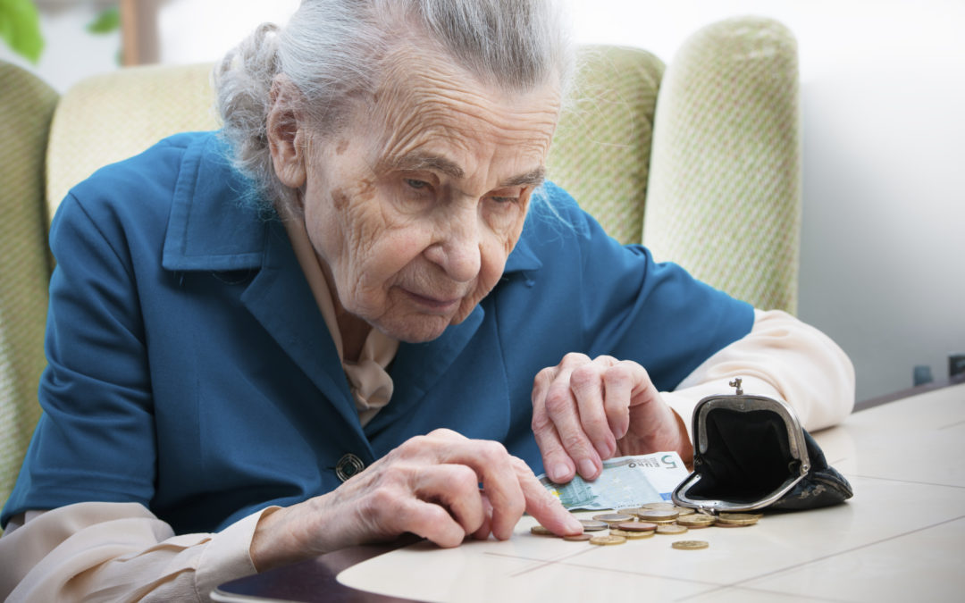 elderly caucasian woman counting money on table